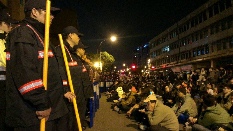 數百名反黑箱服貿學生今（23）晚8點多攻進行政院，在正門廣場上靜坐。而政院四周的門口，則被警力封鎖，圖為北平東路的警民對峙狀況。圖：莊豐嘉/攝   