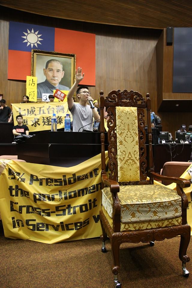 抗議學生把王金平的椅子搬出來，林飛帆在主席台前以會議主席身分宣布，服貿審查會議開始，現場響起歡呼聲。圖2之1：   圖：林雨佑/攝
