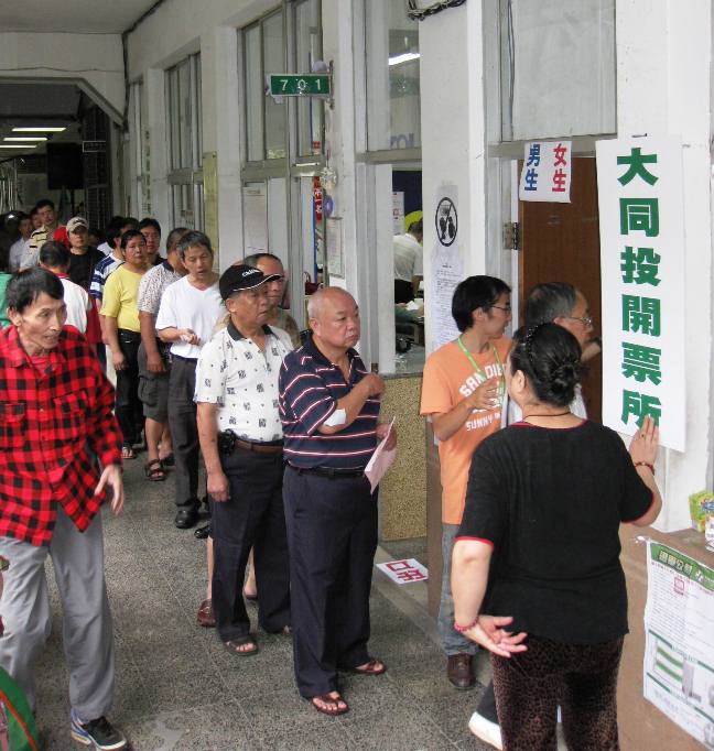民進黨今（27)日進行黨主席等選舉，黨員在投票所前排隊要進入投票。圖：林朝億/攝   