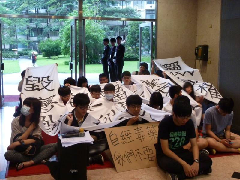 中國醫藥大學等中部大專院校數十名學生今(20)天以靜坐方式，在馬英九總統6週年就職演說現場大廳，以舉標語「反對自經區」等布條表達學生的訴求和抗議。圖：謝莉慧/攝   