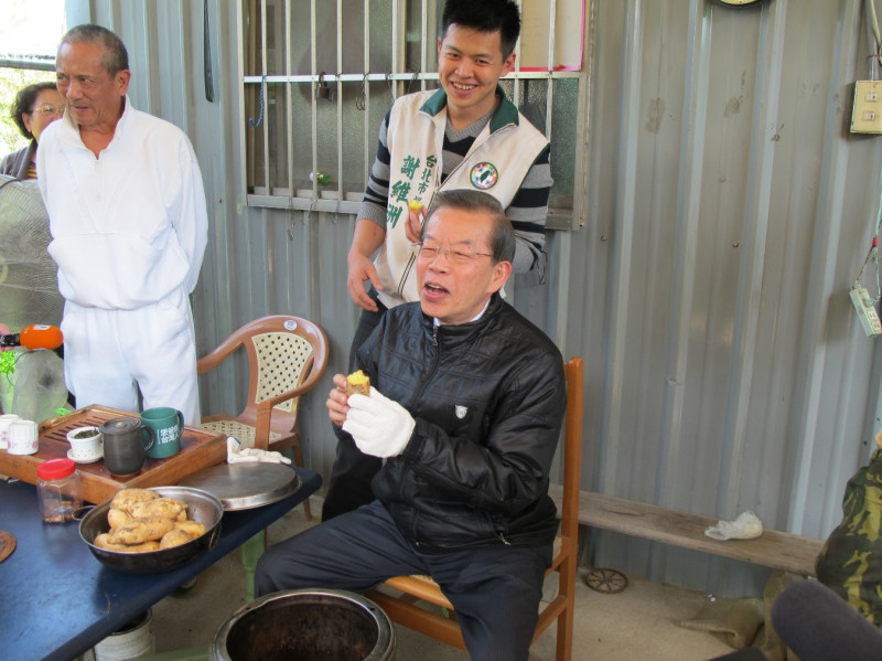 前行政院長謝長廷與兒子謝維洲一起吃烤蕃薯。圖：林朝億/攝   