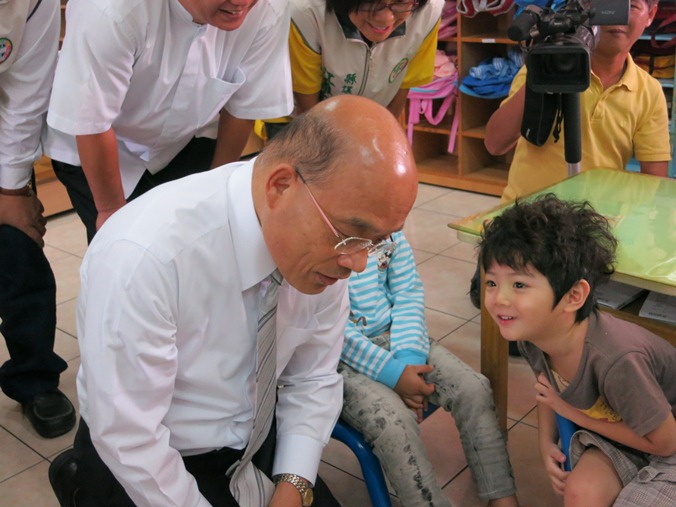 民進黨主席蘇貞昌18日前往彰化縣溪州鄉公立幼稚園視察幼兒餐點時，看到一位幼童滿頭捲髮，靠過去開自己頭上無髮的玩笑。圖：林朝億/攝   