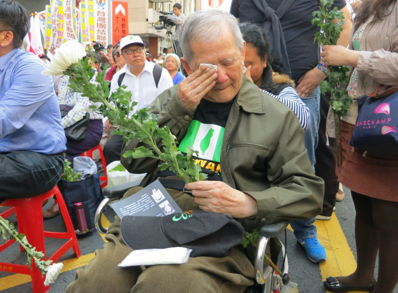 83歲李榮昌拿著鮮花、坐在輪椅上，想起罹難的父親李瑞漢，還是頻頻拭淚。圖：林朝億/攝影   