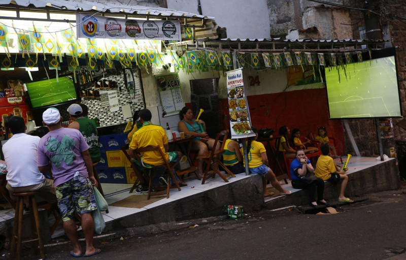 位於里約熱內盧貧民窟的民眾，正在觀看世足賽中巴西對喀麥隆之戰。圖片來源：達志影像/路透社   