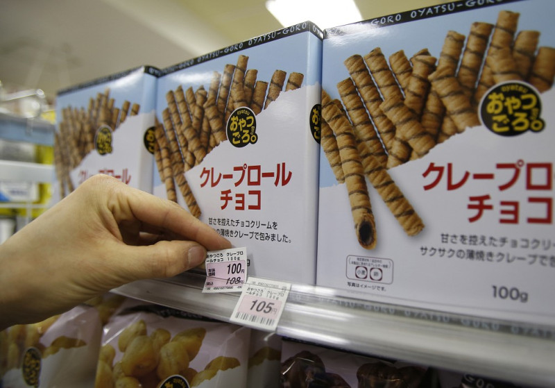 日本便利商店的員工正在更換調高消費稅後的價格標籤。圖片來源：達志影像/路透社   