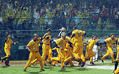 中華職棒獅象爭霸總冠軍賽第 5場，22日晚間在新莊棒球場舉行。兄弟象以5比4的成績勝統一獅，兄弟象球員們興奮地在雨中奔跑。中央社   
