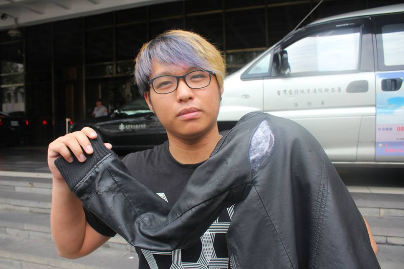 428當天被警方打傷的沈柏耀，拿著當時被警方扯破的皮衣出席台北地方法院前的記者會。圖2之1：林雨佑/攝   