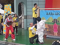 民主進步黨31日在板橋音樂公園舉辦「反核親子劇─核裡有怪獸」活動，黨主席蘇貞昌（前左）協助小朋友限
時穿上隔離衣。圖片來源：中央社。   