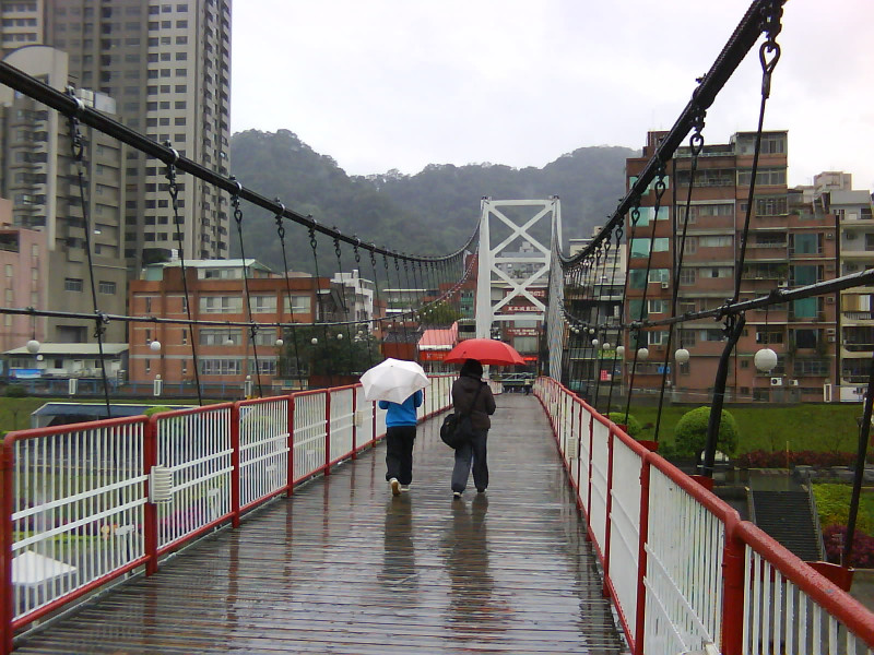 圖為碧潭風景區，因為天冷下雨不斷，行人撐傘，姍姍行過。
圖片來源: 李雲深/攝影   