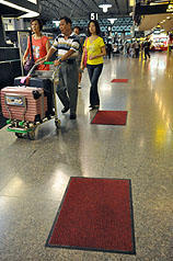 台灣周邊3個颱風生成，挾帶豪雨，桃園機場第二航廈出境大廳屋頂漏水，為防雨滴濕滑導致旅客摔傷，航站擺放小地毯接水。圖片來源：中央社   