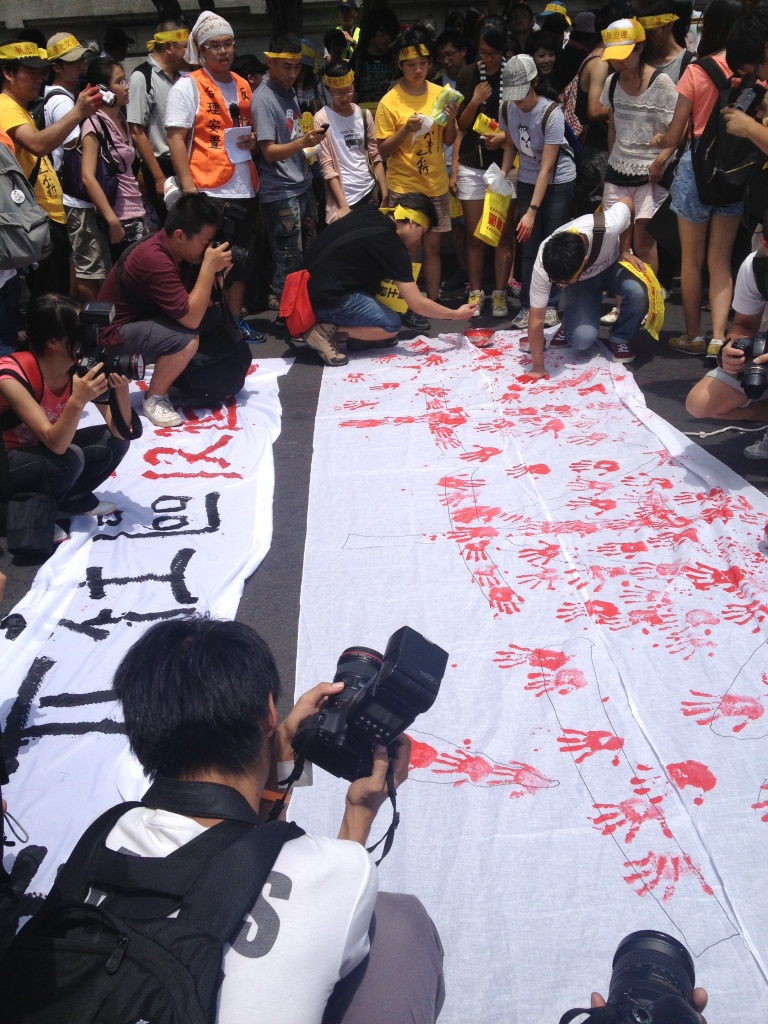 現場聲援民眾用手滿紅墨水，印在有「六本木」字樣的白布上，控訴政府血淚開發。圖：施懿倫/攝   