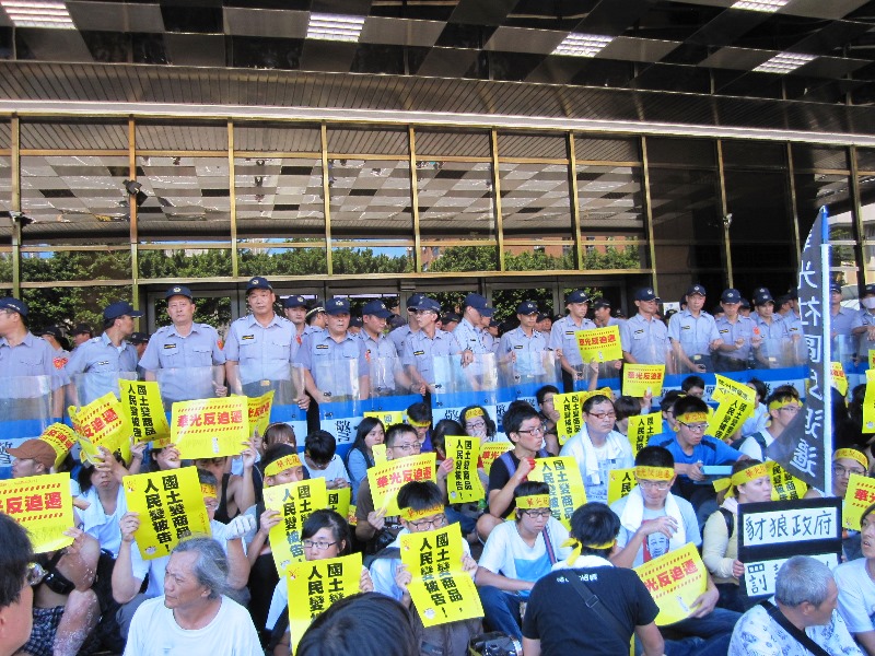 聲援華光社區的200多位民眾今（27）日正午突襲法務部，於玻璃門外就地靜坐，並要求法務部官員出來面對。圖：王立柔/攝   