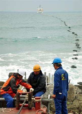 中央氣象局委託日本NEC公司建置台灣第1套光纖海纜地震儀與海洋物理觀測系統，24日在宜蘭頭城海邊登陸。圖片來源：中央社   