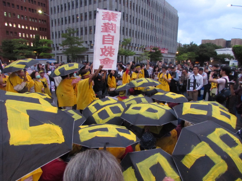 華隆自救會在現場撐起黑傘，要求修正勞基法第28條。圖：邱珮文/攝   