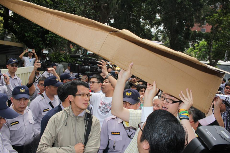 賴中強等人舉起大型紙飛機，要送進行政院內，遭警方口頭警告。圖：林雨佑/攝   