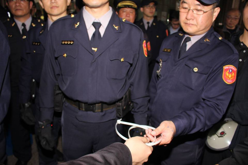 警察從林于倫手上接過束帶。圖：林雨佑/攝   