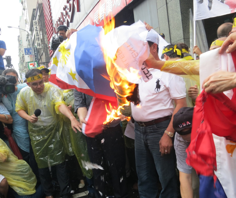 愛國同心會13日在菲國代表處前，火燒菲律賓國旗表達對於該國公務船槍殺台灣漁民的憤怒。圖：林朝億/攝   