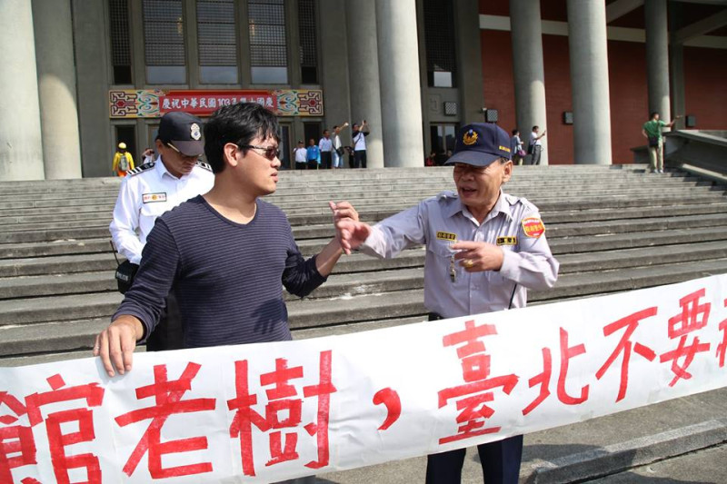 松菸護樹志工團在國父紀念館階梯上拉布條，隨即遭到警衛阻止勸離。圖2之2：林雨佑/攝   