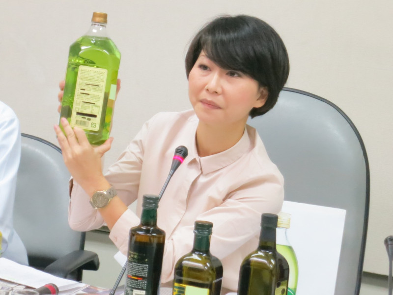 民進黨立委陳亭妃11日拿出多瓶號稱「原裝進口橄欖油」，但條碼卻都跟宣稱的產地國不符。圖：林朝億/攝   