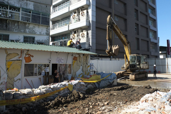 台北市文林苑都更案今（5）日上午再度爆發衝突，建商今天早上派出工人要來架設圍籬，再度與聲援王家的學生發生衝突，工人將怪手開到14號組合屋後，用怪手在組合屋上方揮舞手臂，威脅意味十足。圖：聲援學生許哲韡提供   