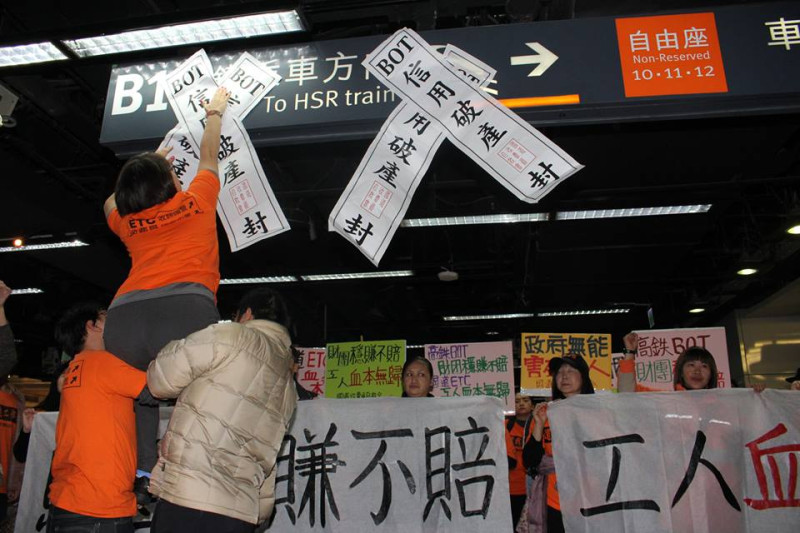 收費員16日在高鐵乘車方向指示牌上貼上自製封條，象徵高鐵代表BOT信用破產。圖3之1：林雨佑/攝   