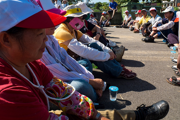 華隆紡織工會會員及聲援團體200多人27日上午在華隆頭份總廠大門前靜坐，華隆員工還用繩索綁住脖子串聯彼此，向警察宣示一旦動手，就是逼他們集體去死。圖片來源：華隆工會臉書   