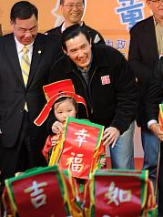 總統馬英九（中）20日出席「天使寶貝 關懷無限」總統府歲末聯歡童樂會，接受小財神送來的禮物。圖片來源：中央社   