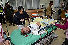 1輛搭載新北市旅客的遊覽車，9日在新竹縣尖石鄉山區翻落山谷，獲救的旅客送醫急救。圖片來源：中央社。   
