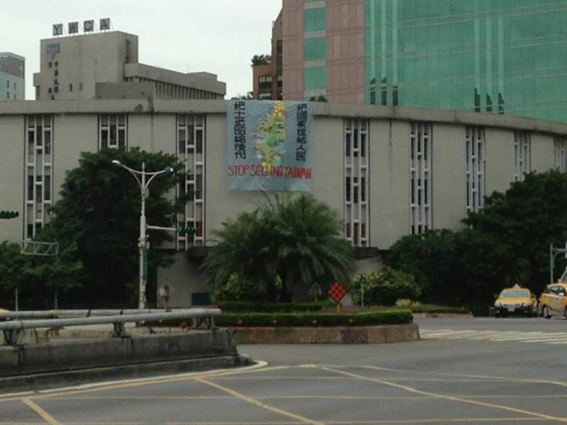 在潑漆行動結束後，行政院對面的高樓不知何時懸掛起「把土地留給後代，把國家還給人民」的巨幅布條。圖3：翻攝自Yulin Huang臉書   