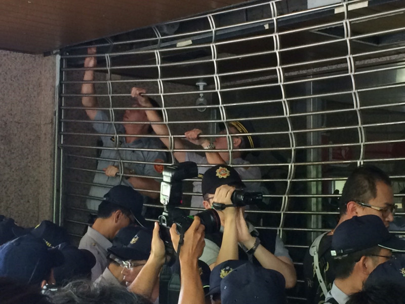 警方除強行降下鐵門外，還在一旁進行蒐證工作。圖：符芳碩/攝   