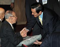 總統馬英九（右）29日出席慶祝建國100年暨第33屆榮民節嘉年華會，致贈禮物給與會百歲榮民。圖片來源:中央社   