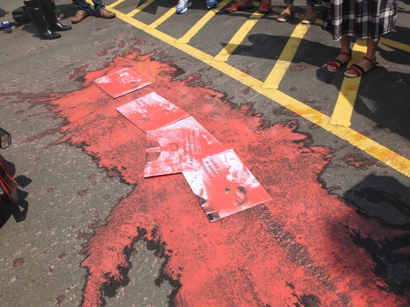 抗議團體在支持助理排除勞基法的大學校長圖片上潑紅漆表達不滿。圖：翁嫆琄/攝   