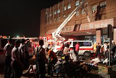 行政院衛生署新營醫院北門分院23日凌晨傳出火警，救難人員忙著疏散院內病患，行動不便的急重症患者被集中在院前廣場待援。圖片來源：中央社。   