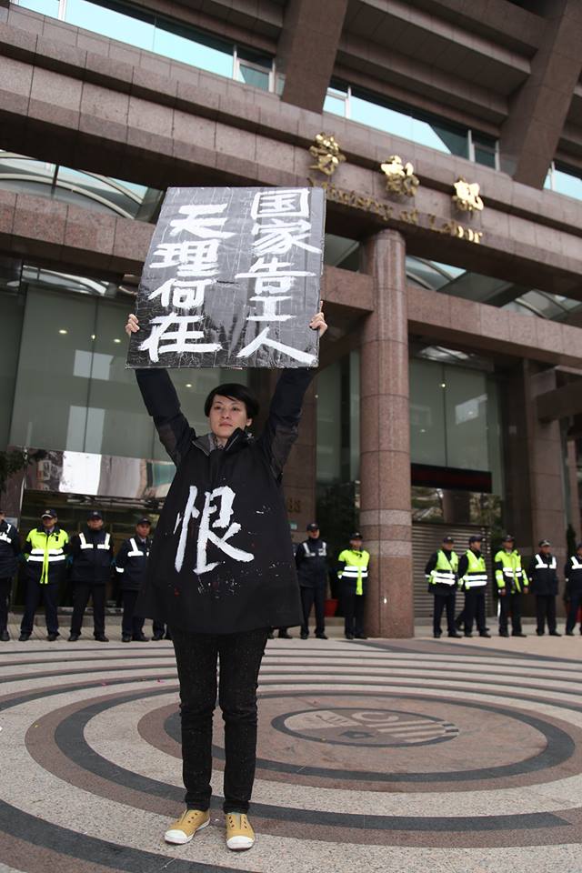 關廠工人發言人陳秀蓮於會後，拿著牌子以勞動部為背景拍照。圖3之3：林雨佑/攝   