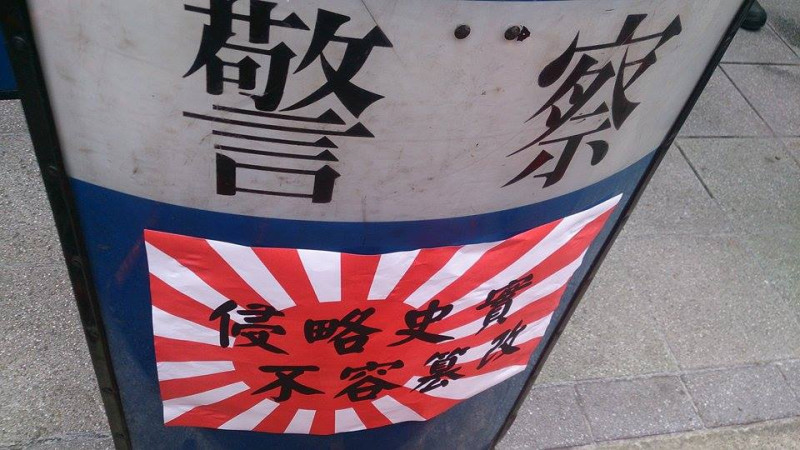 民眾將標語貼在圍欄及警盾上，象徵將訴求送入日本交流協會。圖：王子軒/攝   