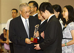 行政院長吳敦義（前左）23日上午還頒獎表揚模範公務人員，希望他們的模範作為，能夠成為台灣向上提升的力量。圖片來源：中央社   