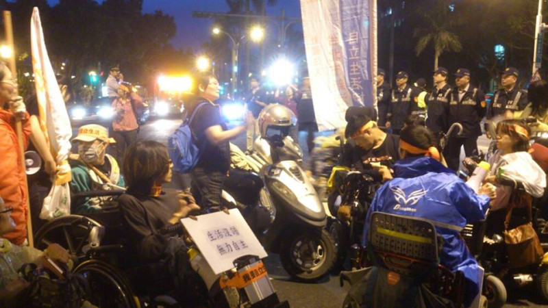 來自全台各地的近百名身障者今(18)天下午聚集在台北街頭爭取「自立生活」的權益，但因訴求未獲正視，傍晚他們用「癱瘓」交通的方式抗議。圖：楊喬皓/攝   