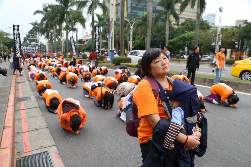 一位收費員媽媽背著襁褓中的嬰兒，走在六步一跪隊伍前。圖：林雨佑/攝   