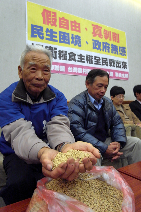 86歲高齡的竹北老農謝見祥手捧台灣農民種植的「台梗19號」稻米，希望政府不要開放中國農產品進口。圖：楊宗興/攝   