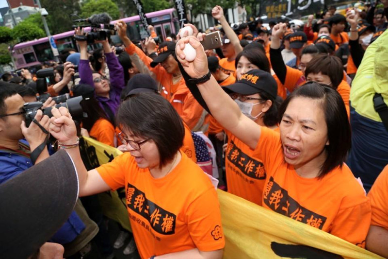 收費員到行政院門口，準備丟出手中的雞蛋。圖：林雨佑/攝   