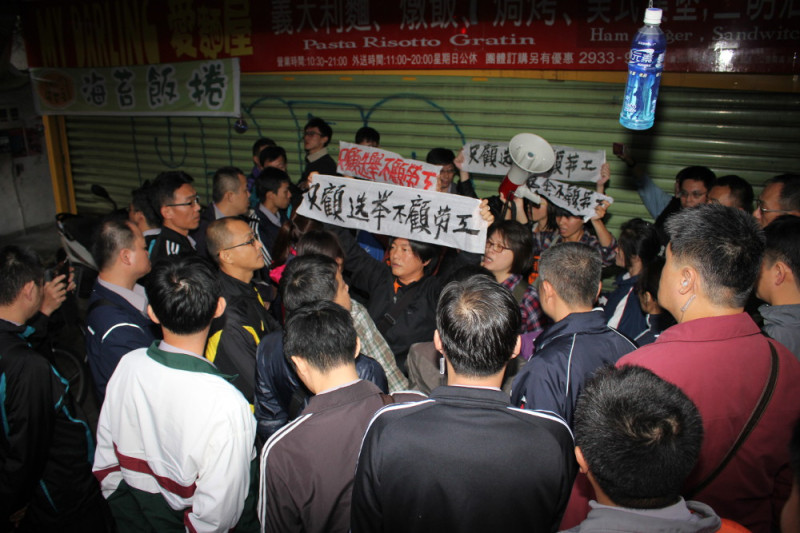 國道收費員自救會6、7成員被近百便衣警察團團包圍在騎樓內，卻仍不斷高喊「只顧選舉 不顧勞工」。圖：林雨佑/攝   