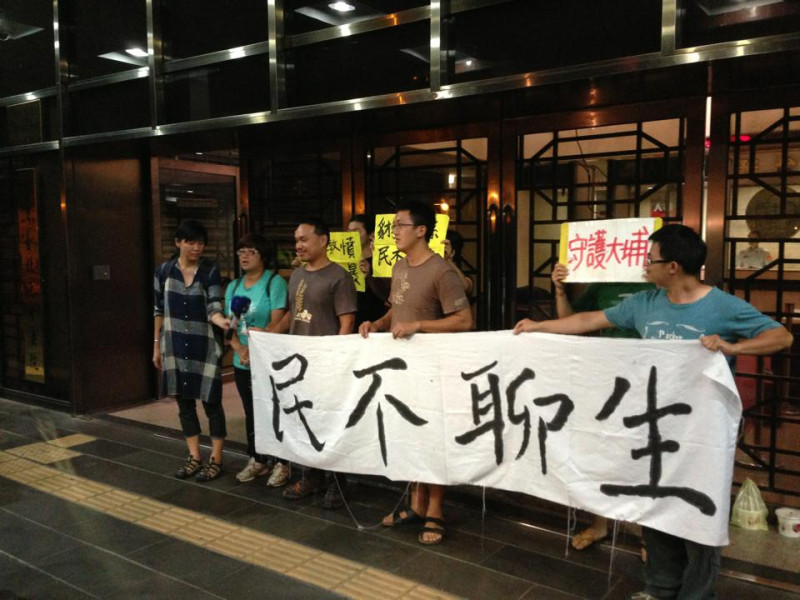 白米炸彈客楊儒門、李建誠19日潑漆後，在台北地檢署拉布條表達理念。圖：翻拍自臉書   