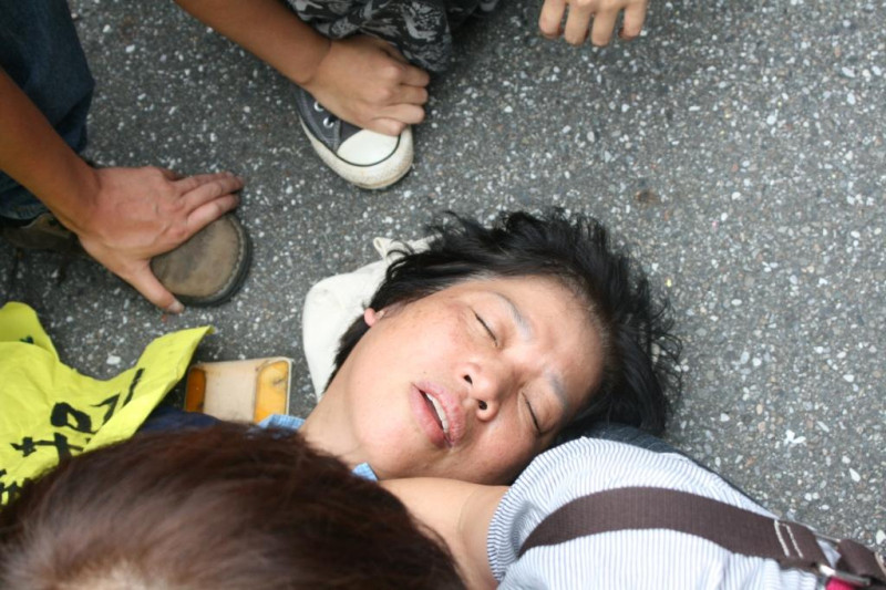 拒拆遷戶張藥房老闆張森文妻子彭秀春在總統府前抗議疑似遭受撞擊導致休克。圖：林良齊/攝   