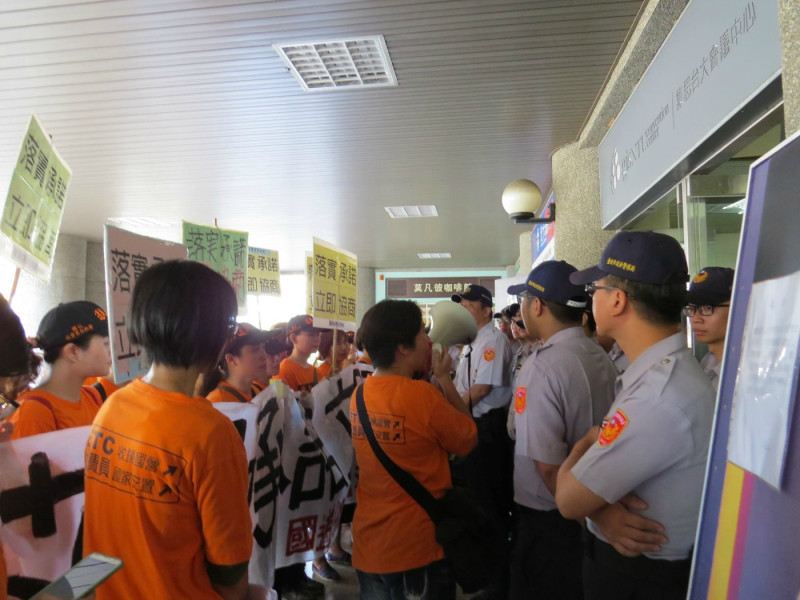 國道收費員自救會成員今(18)日在台大集思會議中心外和警察對峙。圖：蘇恆萱/攝。   
