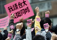 台灣大學學生會性別工作坊今（13）天舉辦「我讀台大，我挺同婚」舉牌聲援活動。圖：中央社   