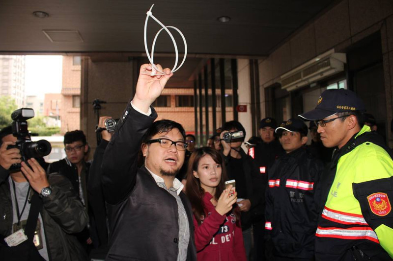 臺左維新總召林于倫高舉束帶，諷刺問警察，「這是誰掉的束帶？」圖：林雨佑/攝   
