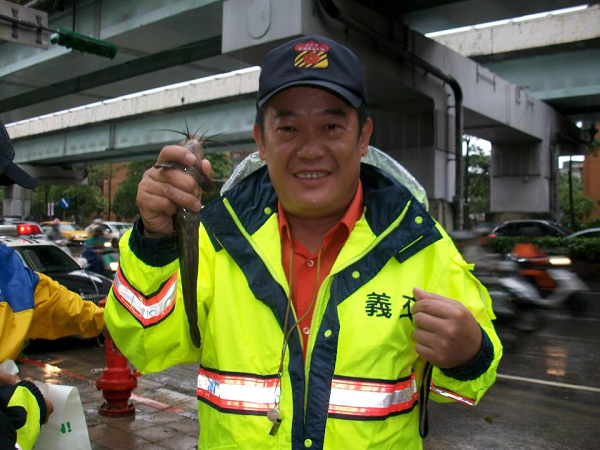 新北市中、永和地區通往台北市的重要道路基隆路，早上則因為大雨成為一條小河，還有交通警察在腳下撿到一隻鯰魚。圖片來源：翻攝自臉書   