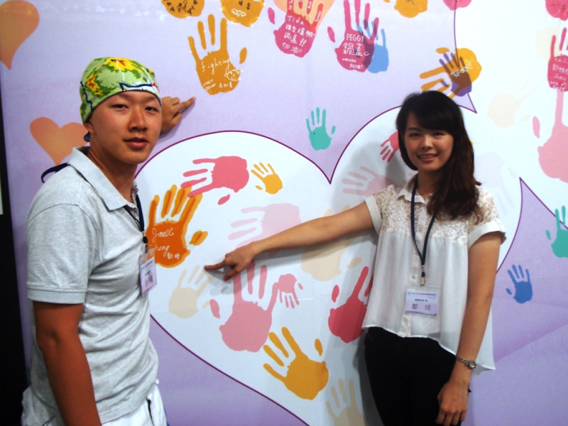 台北大學鄭琪與台科大徐梓隆指著在多益獎學金公益團隊發表會上宣示的手印，表示要將禮納里部落的美帶給全世界。圖：陳柔伊/攝   
