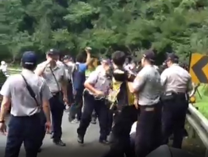 新頭殼記者林雨佑採訪民眾在烏來新烏路阻擋中國國台辦主任張志軍新聞時，遭到多位警察以拉扯阻擋。圖：影片截圖   