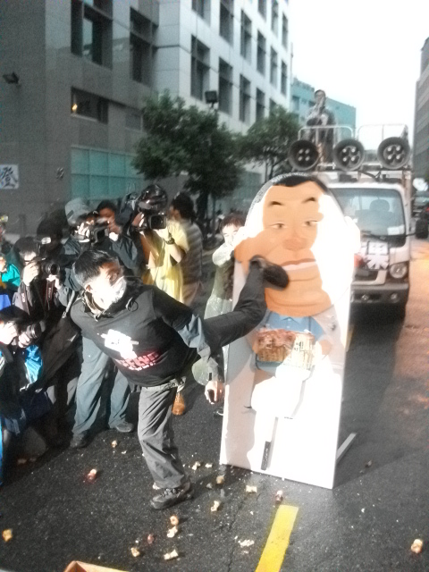 蘋果日報工會今(17)日下午3點在台北總社外封街舉辦「我要蘋果，不要黑手」活動，現場準備了黎智英的人型立牌，參加活動的群眾、壹傳媒員工紛紛將手中的蘋果核扔向立牌，甚至怒踹看板表達不滿。圖：涂鉅旻/攝   
